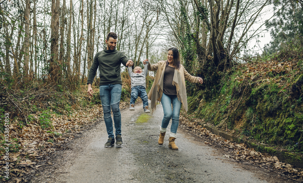 Pregnant woman having fun with family in forest in autumn Pregnant woman having fun with family in forest in autumn