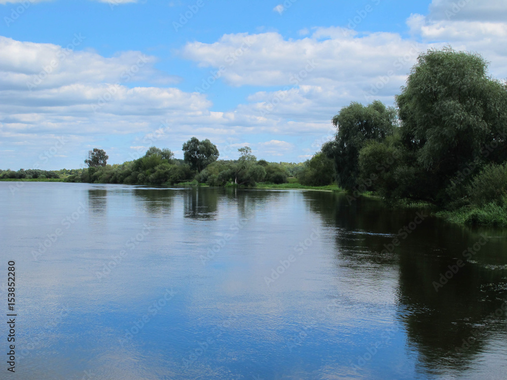 wide river in green banks overgrown with woods wide river in green banks overgrown with woods