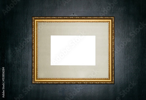 Empty gold frame on a black wooden background copy space