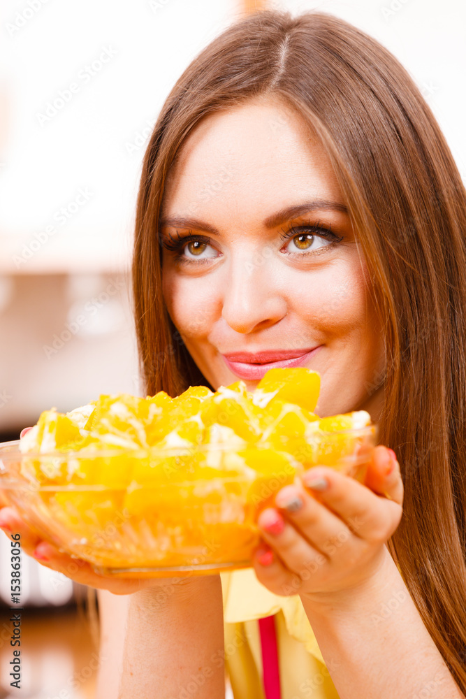 Woman holds bowl full of sliced orange fruits Woman holds bowl full of sliced orange fruits