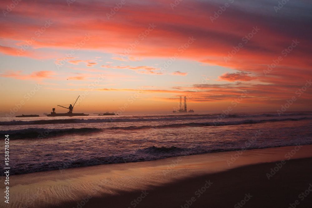 Sunset over submarine at sandy beach
