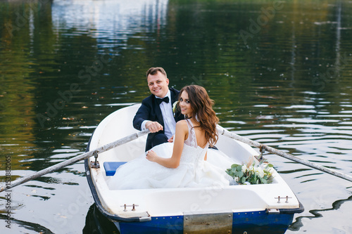 Canvas Print The bride and groom in a rowboat on the lake