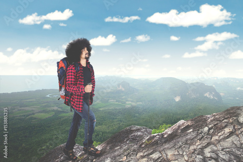Afro man hikes a mountain