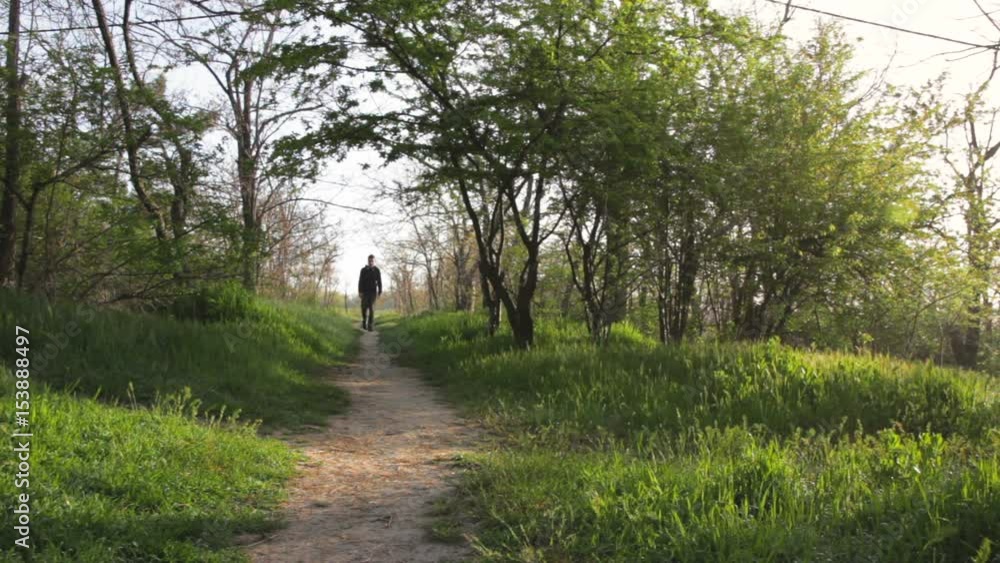 Man following the forest path in the morning. Beautiful sunrise in the forest Man following the forest path in the morning. Beautiful sunrise in the forest