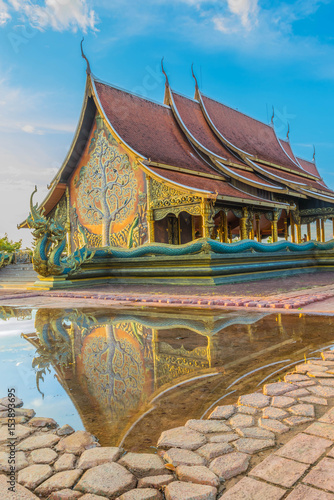 Abstract soft blurred and soft focus semi silhouette of the sunset with the sanctuary of temple,Wat Sirindhorn Ubonrachathani Province Thailand, with the shadow reflected in the water on the floor,the © worranam2w