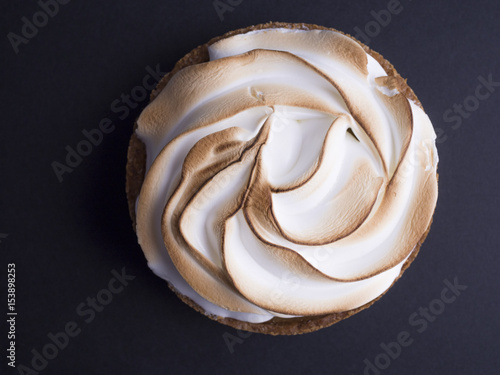 French lemon pie with meringue on top isolated on black background
