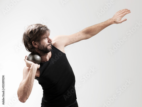 Athlete performing shot put against white background photo