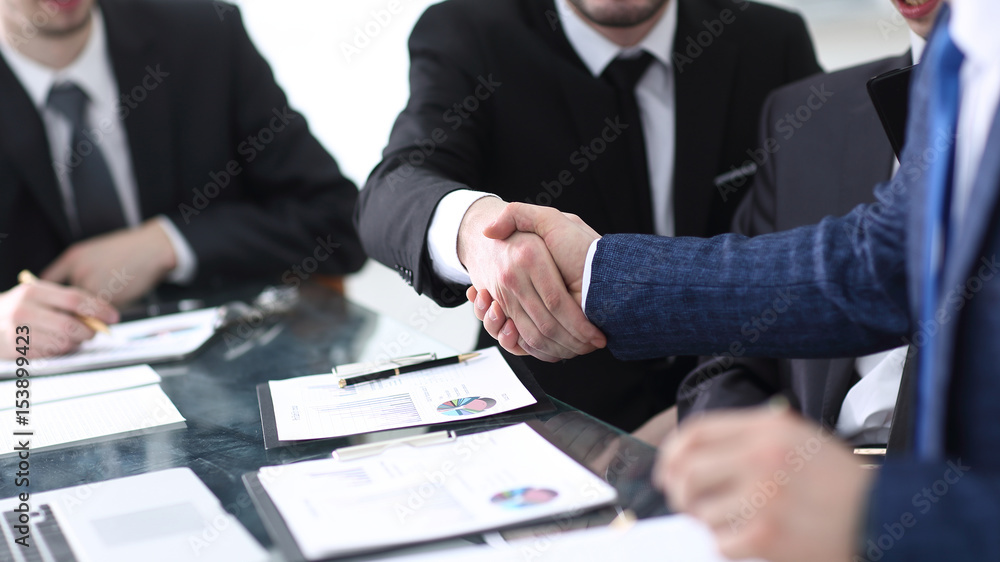 businessman shaking hands to seal a deal with his partner businessman shaking hands to seal a deal with his partner