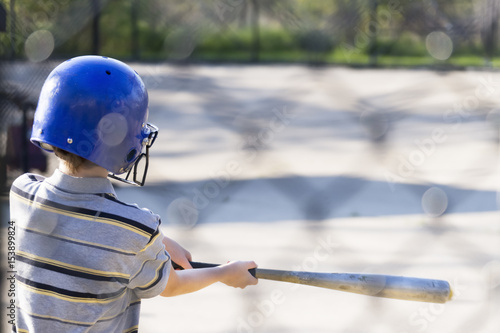 Young boy practicing hitting baseball at the batting cages