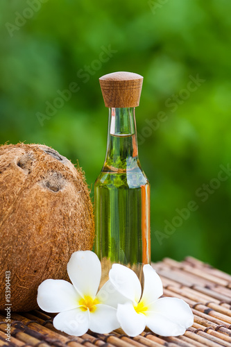coconut oil and coconuts on green background