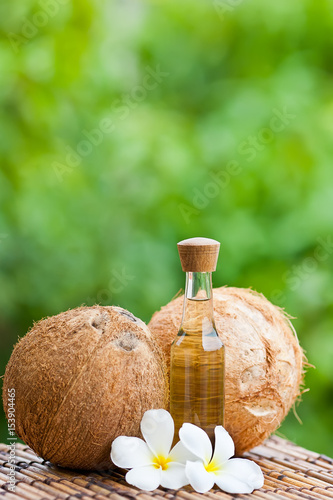 coconut oil and coconuts on green background