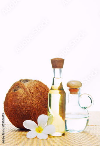 coconut oil and coconuts on green background