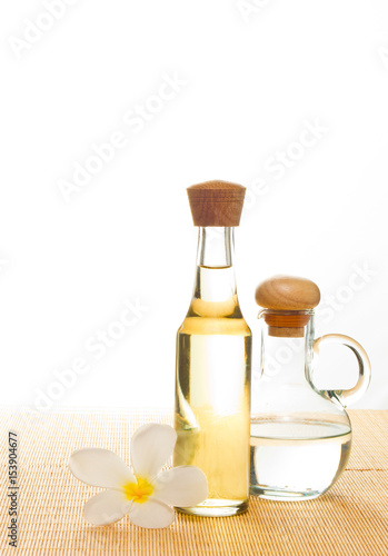 coconut oil and coconuts on green background