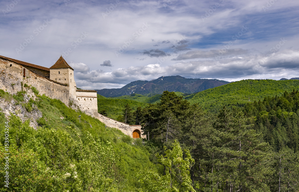 Beautiful spring view of the entrance in the Rasnov citadel in Brasov county (Romania), with Postavaru mountains in the background Beautiful spring view of the entrance in the Rasnov citadel in Brasov county (Romania), with Postavaru mountains in the background