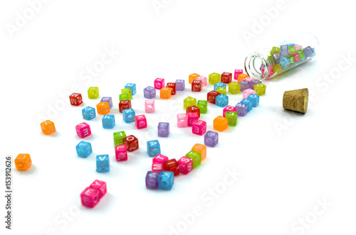 Colourful small cubes with characters random scattered from the vial isolated on white background. Word education concept.