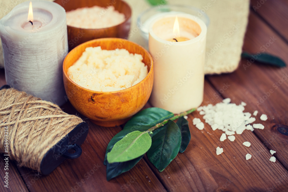 close up of natural body scrub and candles on wood close up of natural body scrub and candles on wood