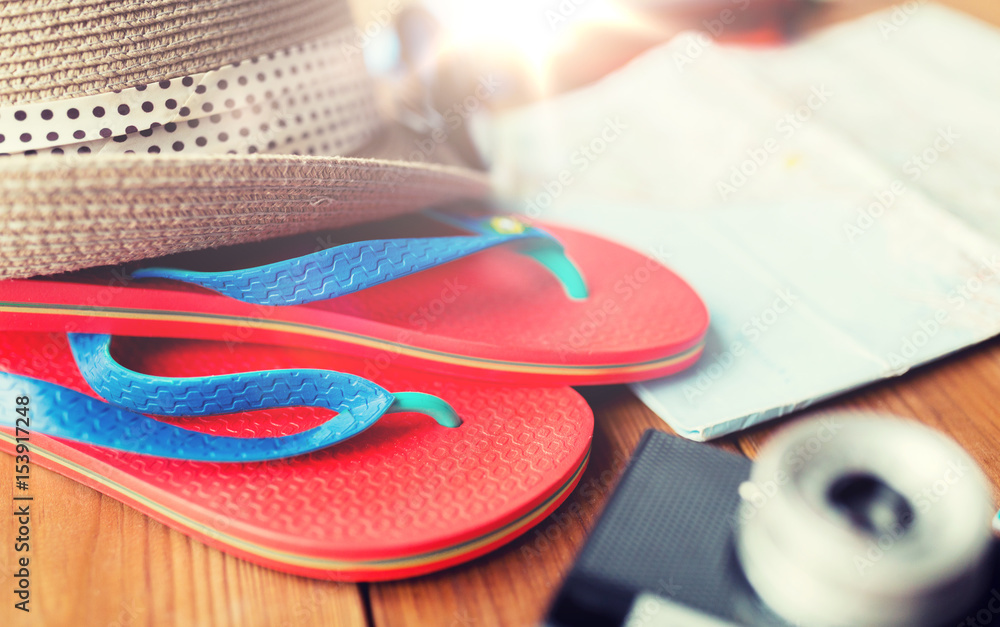 close up of travel map, flip-flops, hat and camera close up of travel map, flip-flops, hat and camera