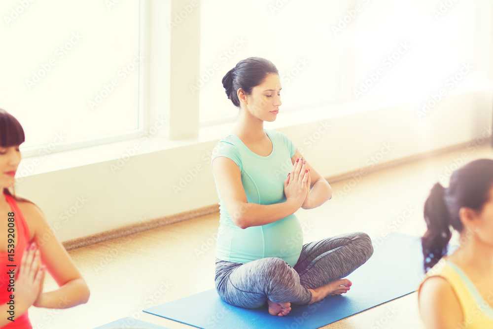happy pregnant women exercising yoga in gym happy pregnant women exercising yoga in gym