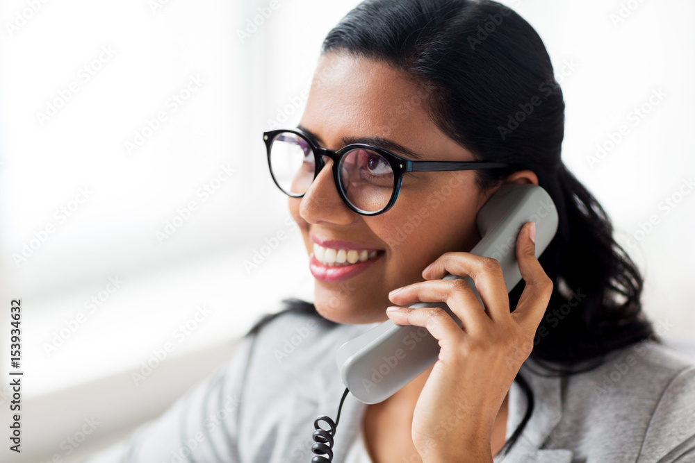 smiling businesswoman calling on phone at office smiling businesswoman calling on phone at office