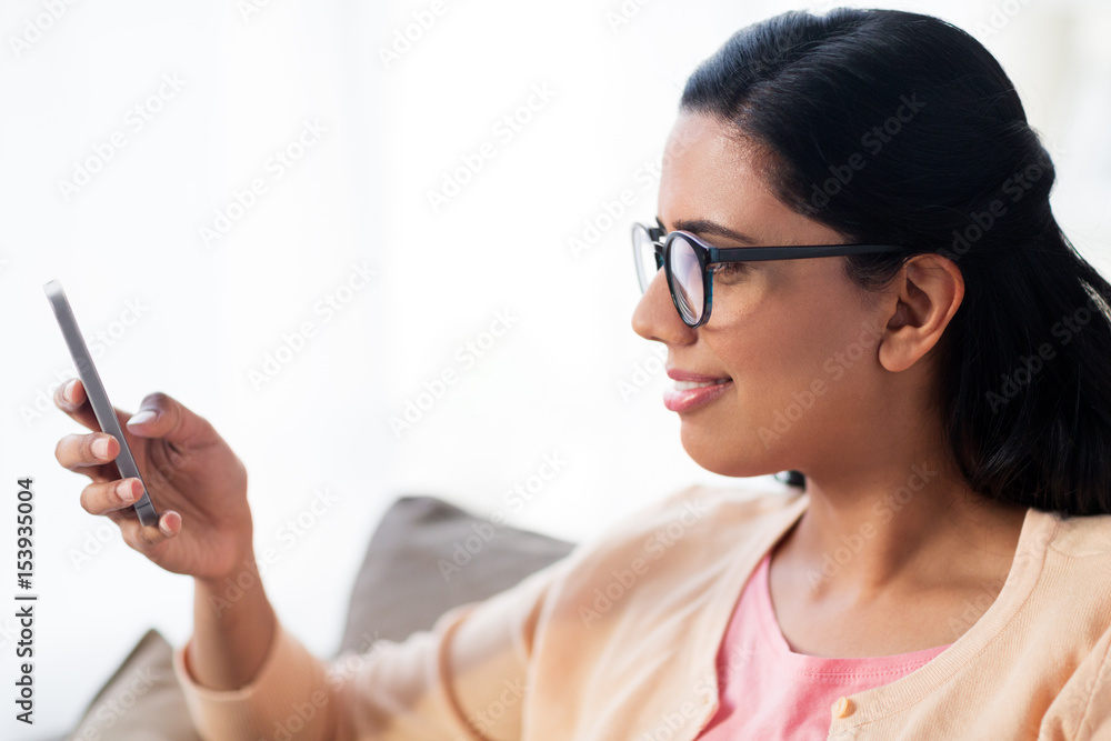 happy woman texting message on smartphone at home