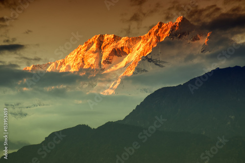 Beautiful last light from sunset on Mount Kanchenjugha, Himalayan mountain range, Sikkim, India. color tint on the mountains at dusk photo