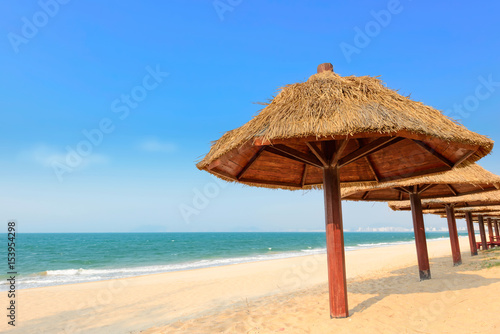 Fototapeta Naklejka Na Ścianę i Meble -  golden straw umbrella on the summer beach