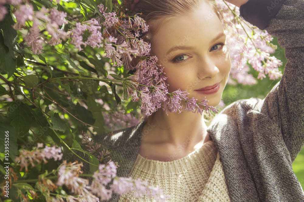 Beautiful red hair ginger slim young woman with fresh skin in casual outfit, posing with flowers. Sunny summer day in park (nature). Daylight Beautiful red hair ginger slim young woman with fresh skin in casual outfit, posing with flowers. Sunny summer day in park (nature). Daylight