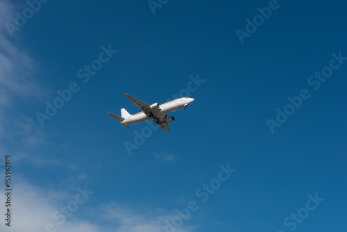 Landendes Flugzeug bei gutem Wetter vor blauem Himmel