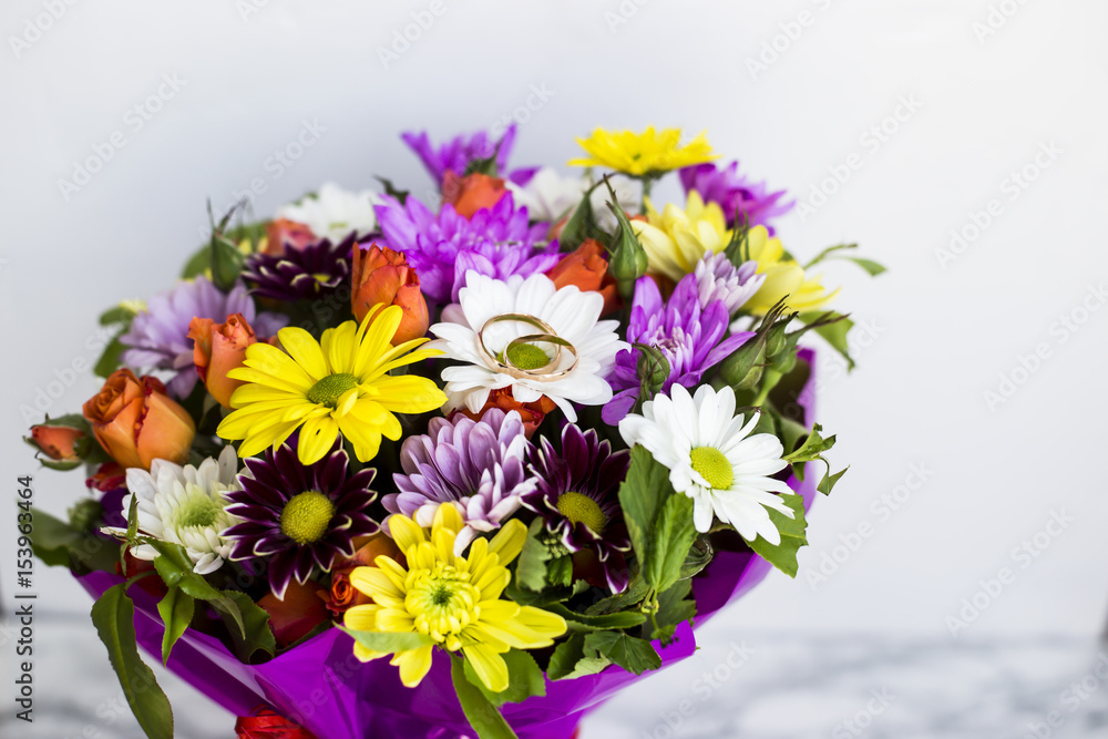 Wedding rings on a bright spring bouquet of the bride