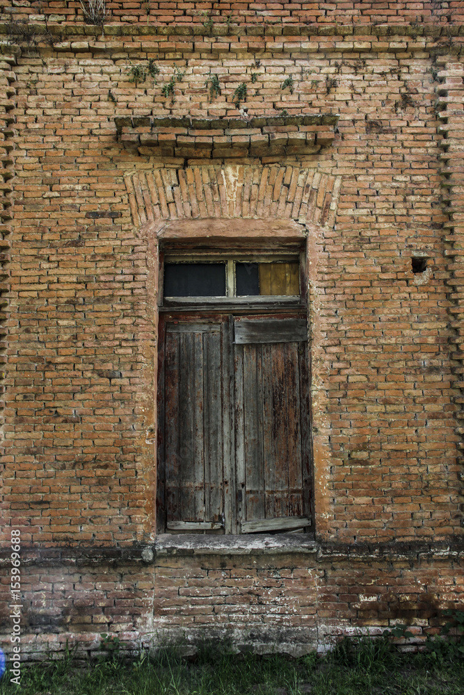 Vieja puerta de madera en pared de ladrillos