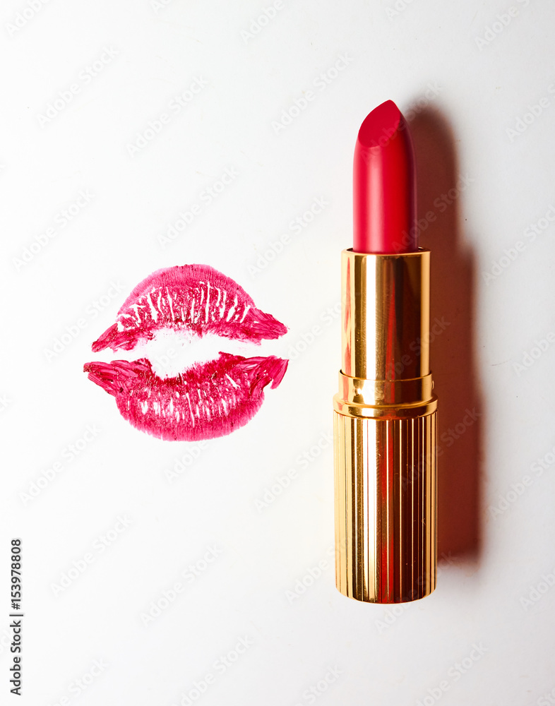 Fototapeta premium red lipstick in golden tube and lip print on a white background