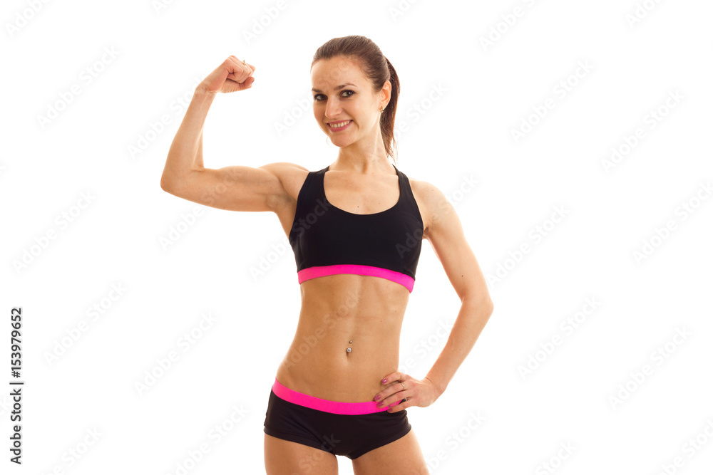 cute athletic girl in a short top and shorts looks straight smiles and shows the biceps cute athletic girl in a short top and shorts looks straight smiles and shows the biceps