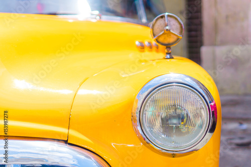 Closeup of yellow classic vintage car in Old Havana, Cuba