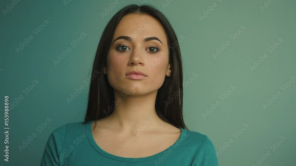 Young woman looking at the camera and smiling. Attractive girl portrait. Blue background Young woman looking at the camera and smiling. Attractive girl portrait. Blue background