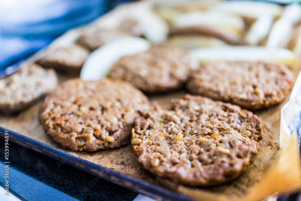 Macro closeup of veggie vegetable vegan burgers on tray for baking Macro closeup of veggie vegetable vegan burgers on tray for baking