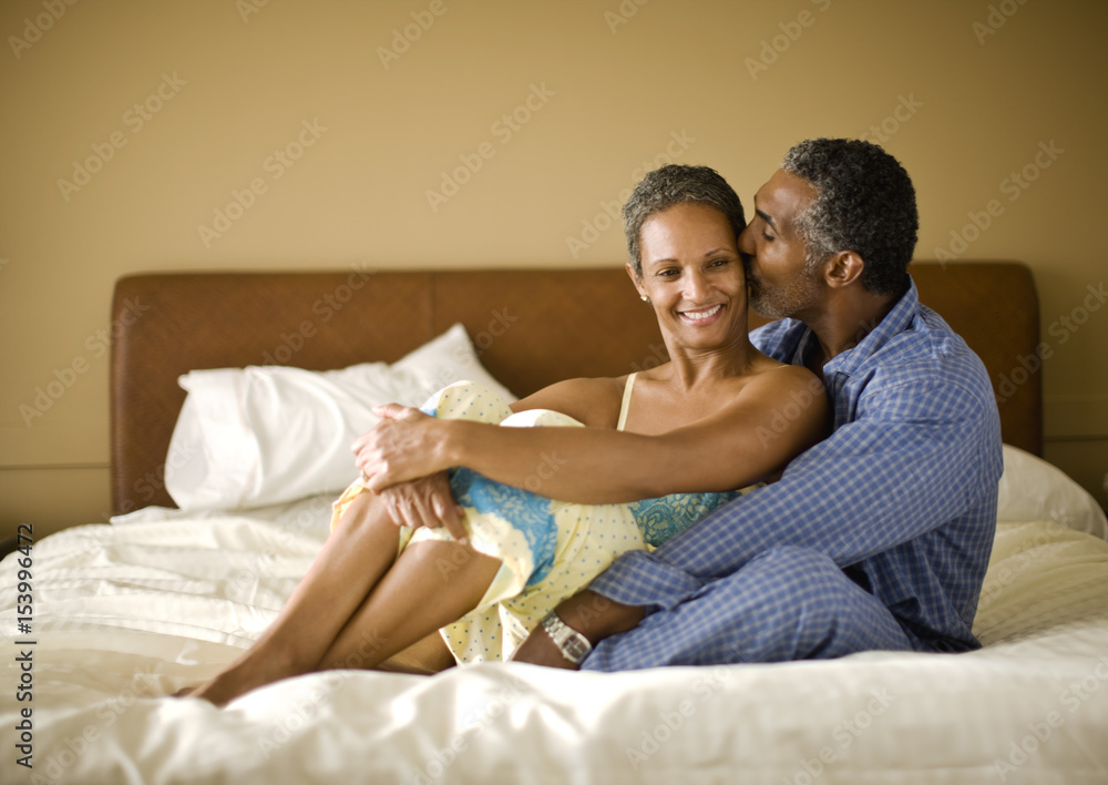 Couple kissing on their hotel bed. Couple kissing on their hotel bed.