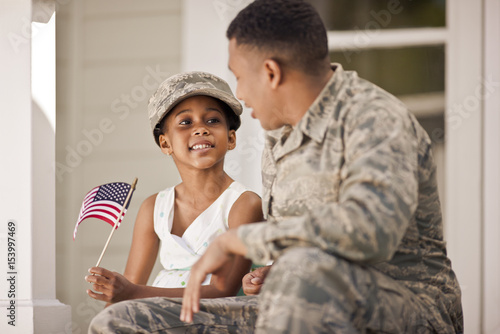 Smiling father and girl sitting on steps
