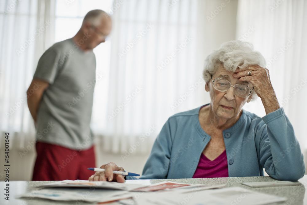 Anxious elderly couple worry about how they will pay all the bills they have received. Anxious elderly couple worry about how they will pay all the bills they have received.