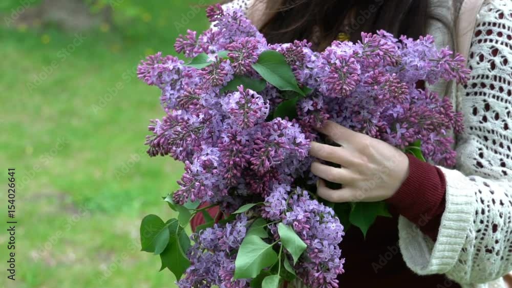 Woman holding a bouquet of lilacs in blossom. Woman holding a bouquet of lilacs in blossom.