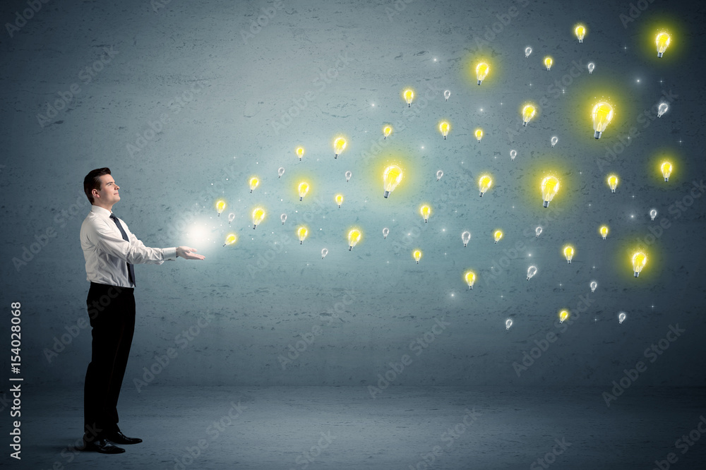Fototapeta premium Businessman holding lightbulbs