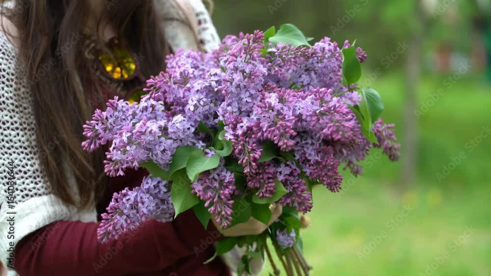 Woman holding a bouquet of lilacs in blossom. Woman holding a bouquet of lilacs in blossom.