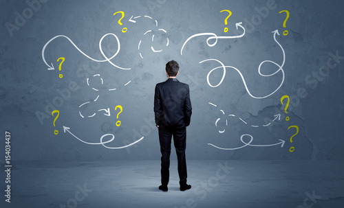 Unsure businessman with question marks