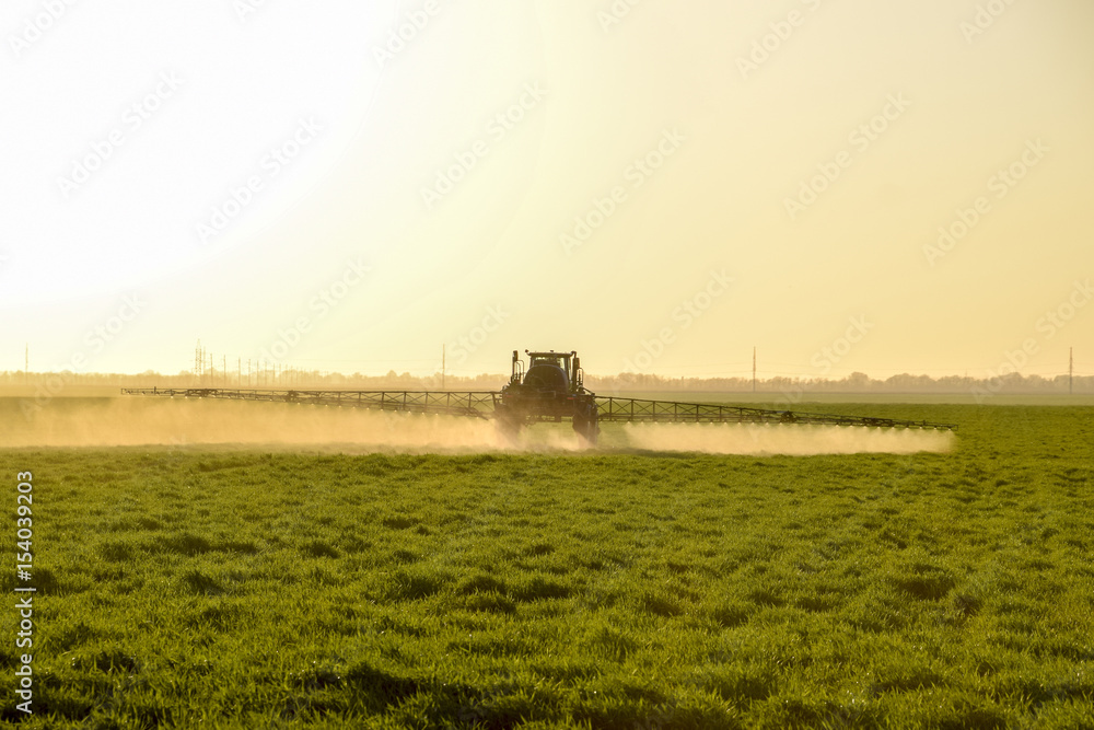 Stockfoto Tractor on the sunset background. Tractor with high wheels is