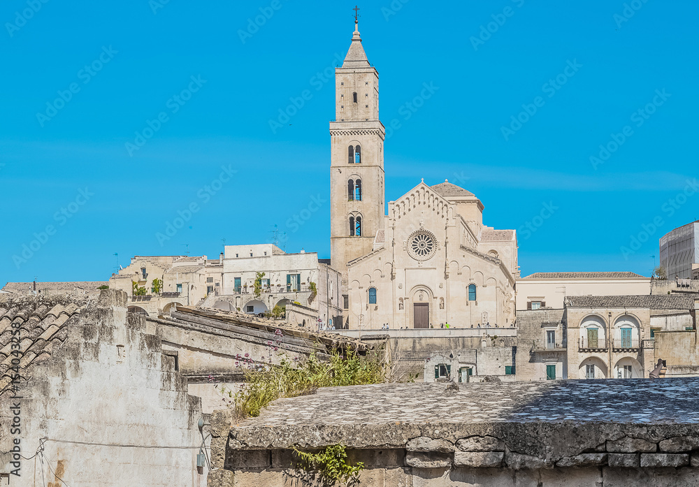 panoramic view of typical stones (Sassi di Matera) with church in Matera UNESCO European Capital of Culture 2019 on blue sky