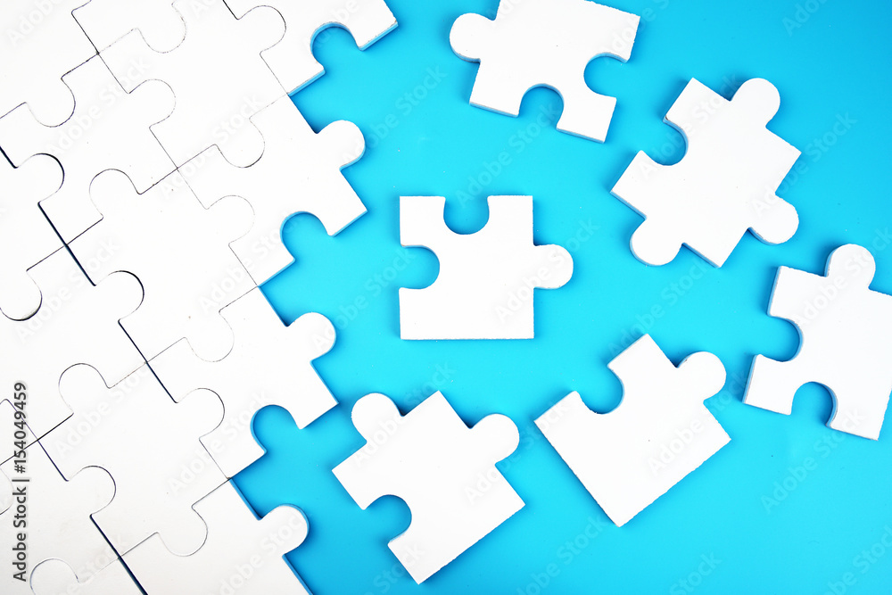 White jigsaw puzzle on blue background. White jigsaw puzzle on blue background.