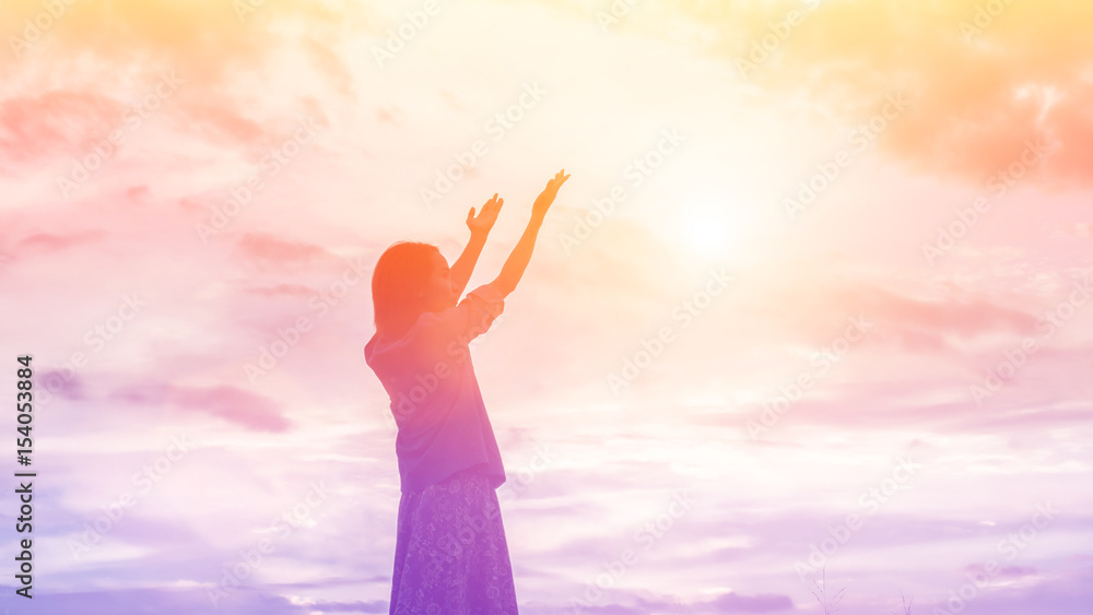 Silhouette of woman praying over beautiful sky background Silhouette of woman praying over beautiful sky background