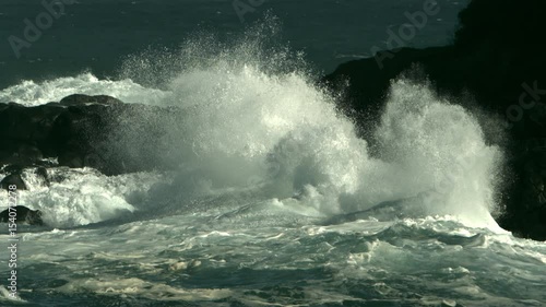 Ocean waves crashing into rocks in slow motion