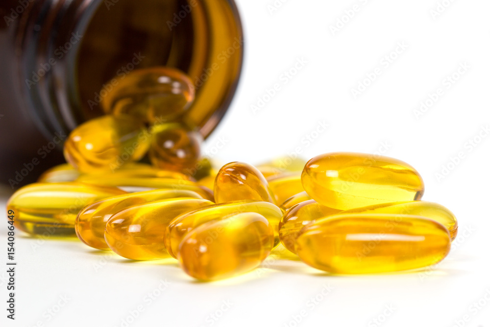 Close up fish oil capsules from bottle isolated on white background, Have a copyspace for your text Close up fish oil capsules from bottle isolated on white background, Have a copyspace for your text