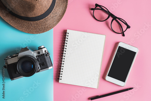 Flat lay fashion style with camera, smart phone, notebook and hat