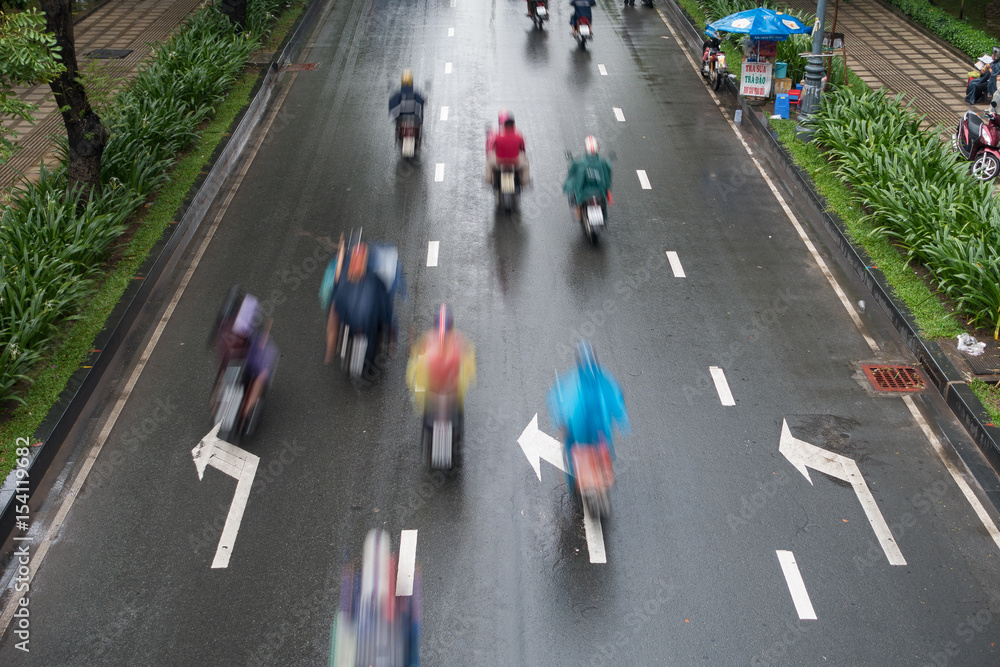 HO CHI MINH, VIETNAM - MAY 11 2017: Blurred focus. Undefined motorcycle traffic in rain. Is located in the South of Vietnam, is the country's largest city, population 8 million